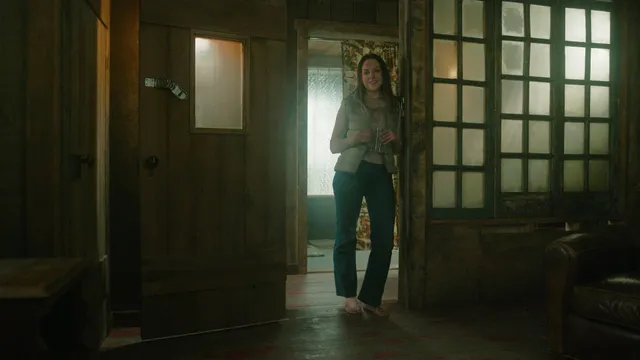 Elizabeth Gillies standing indoors during a screen scene.