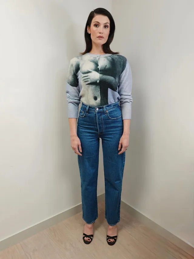 Gemma Arterton posing indoors in jeans and black sandals.