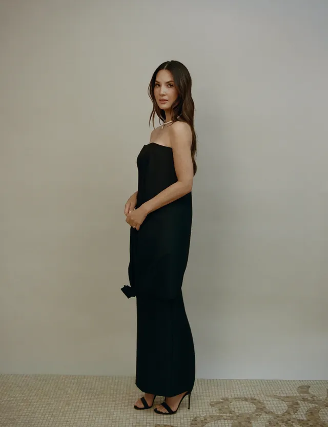 Olivia Munn turning in a long black dress and strappy heels.