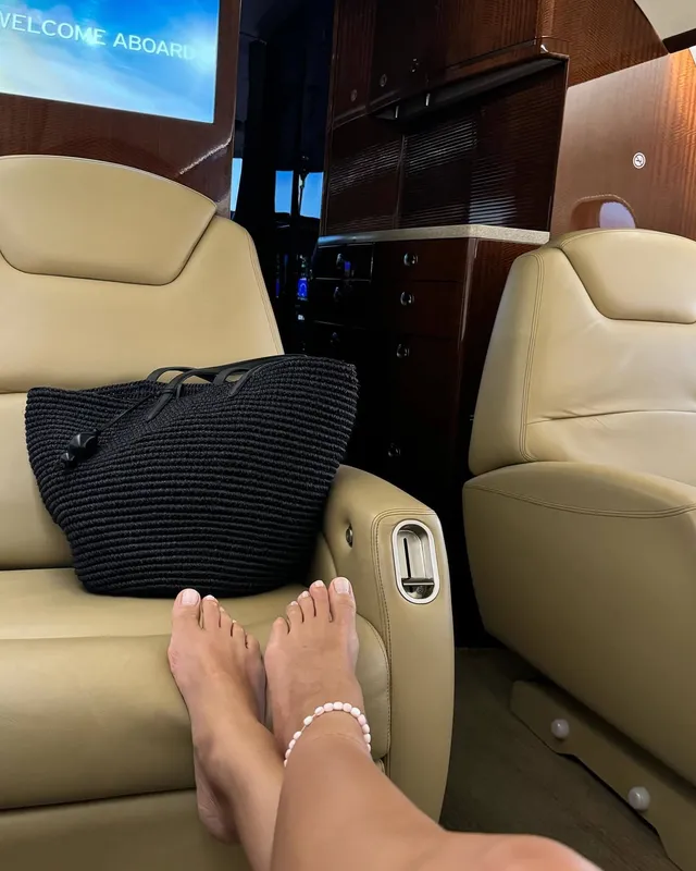Irina Shayk bare feet in a cream airplane seat.