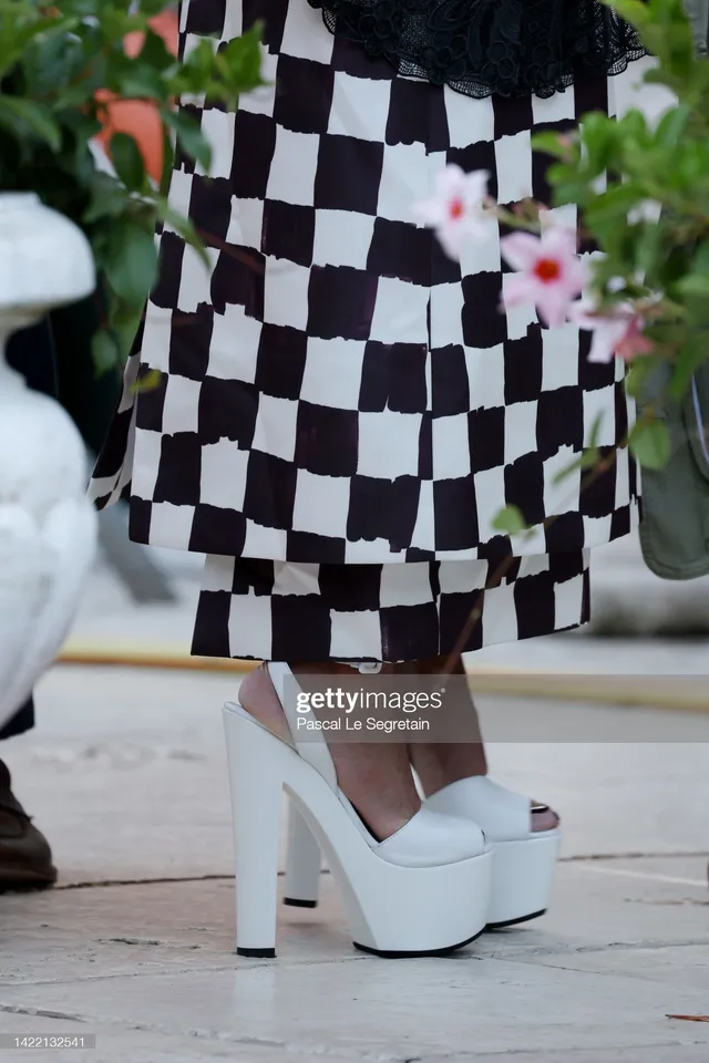 Tessa Thompson wearing white platform sandals beneath a checked dress.