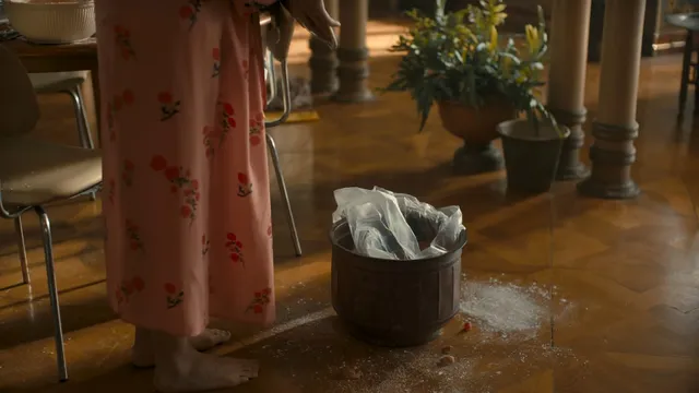 Jodie Comer standing beside a bucket in a stage scene.