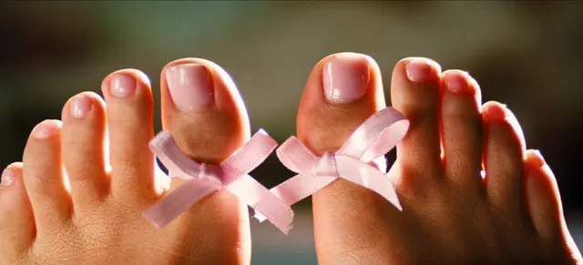 Sydney Sweeney: close view of painted toenails with pink bow toe rings.