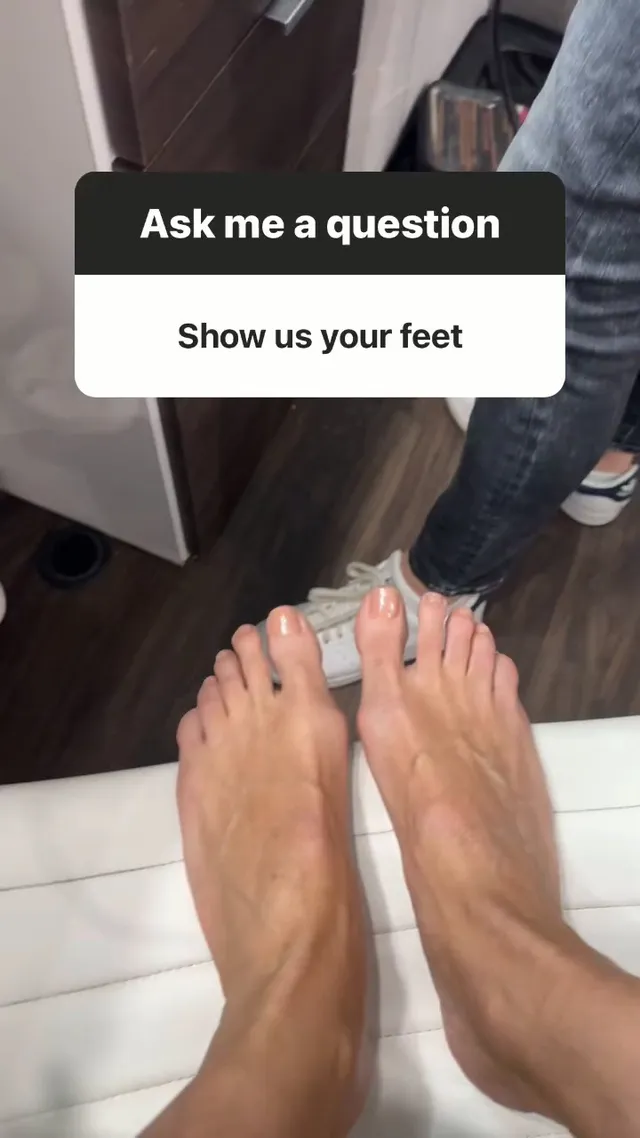 Heidi Klum taking a mirror photograph of her bare feet.
