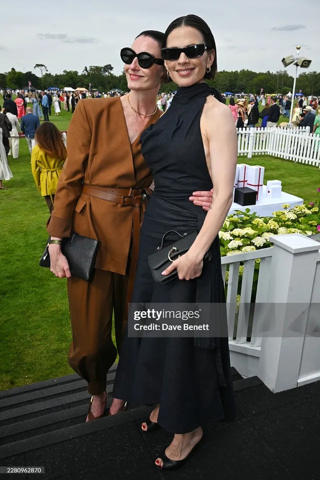Hayley Atwell posing with a companion on outdoor seating.