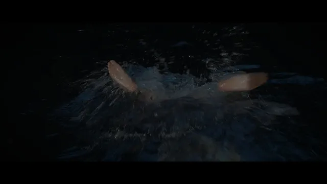 Daisy Ridley swimming in a dark screen scene.
