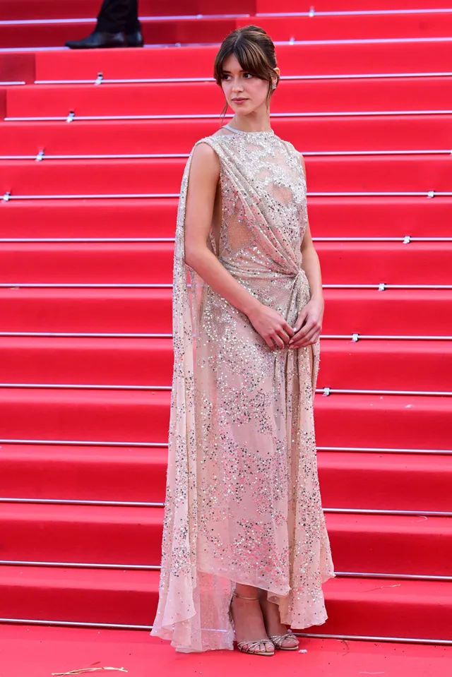 Daisy Edgar-Jones posing on red-carpet stairs in a pink dress.