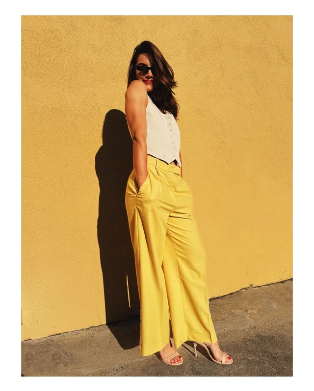 María Gabriela de Faría wearing yellow trousers and flat sandals.