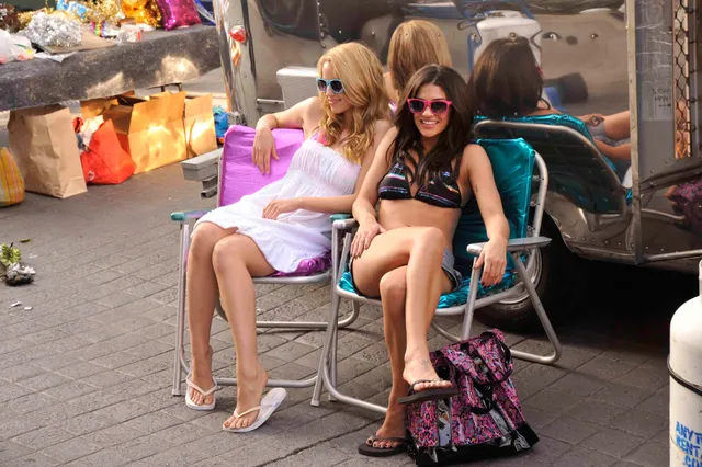 Dianna Agron sitting beside a companion in a casual outfit.