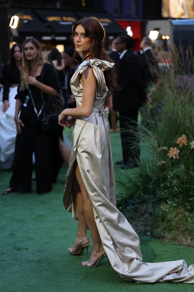 Daisy Edgar-Jones turning at a premiere in a silver gown.