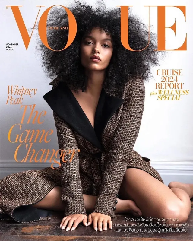 Whitney Peak posing in a dark patterned jacket for a Vogue cover.