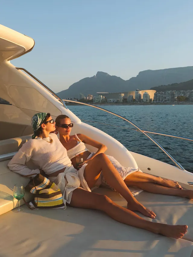 Taylor Hill relaxing barefoot beside a companion on a boat deck.