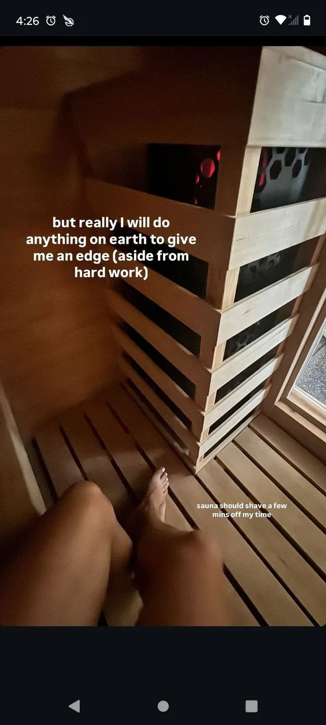 Claire Holt resting beside a sauna bench.