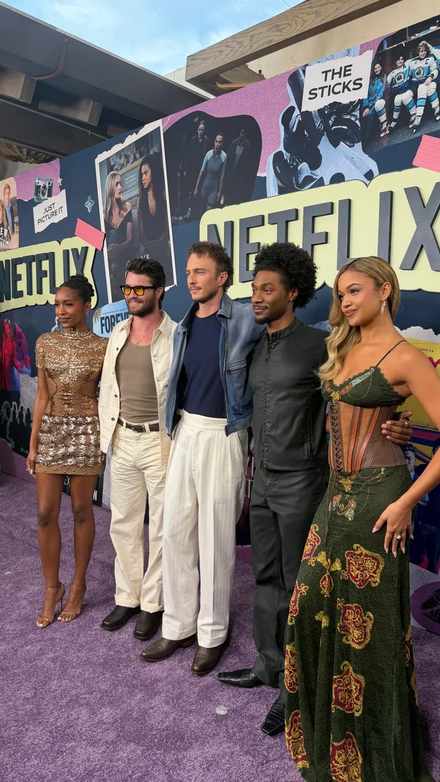 Carlacia Grant posing with fellow performers in a gold dress and heels.