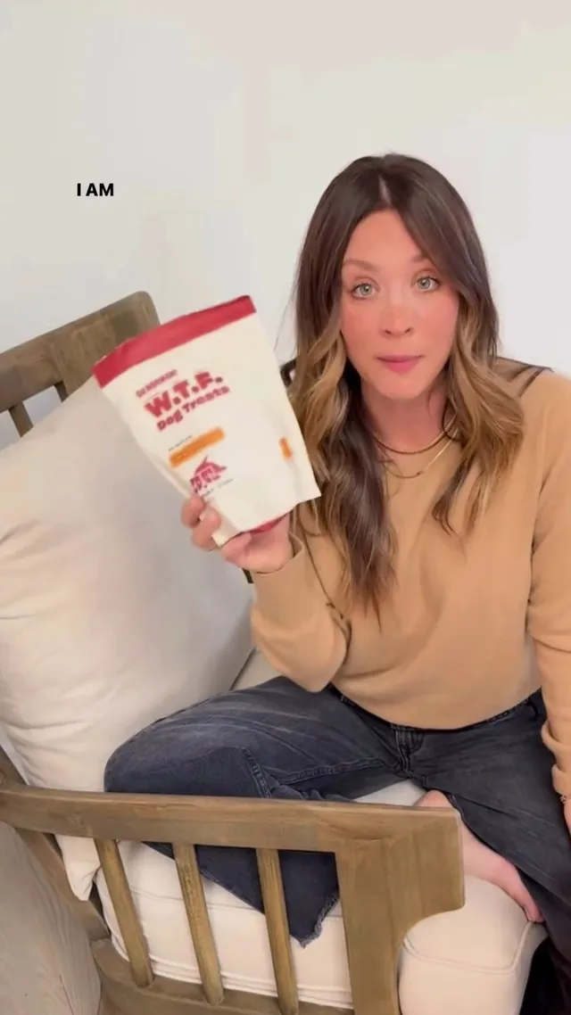 Kaley Cuoco sitting at a dining chair while holding a food box.