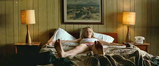 Yvonne Strahovski reclining on a bed during a screen scene.