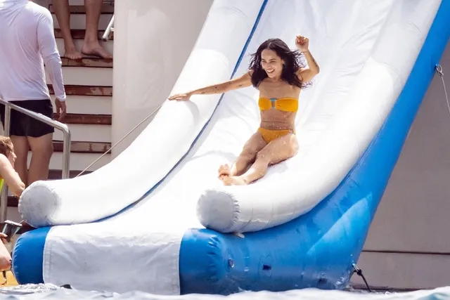 Zoë Kravitz sitting at the bottom of a boat slide.