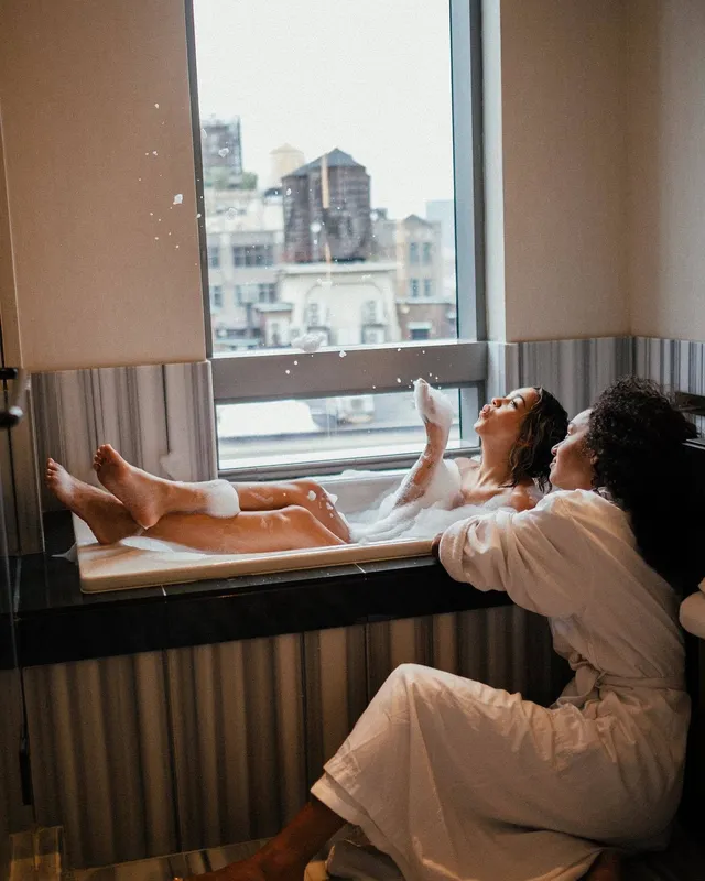 Madison Bailey sitting in a bathtub with bare feet resting on the edge.
