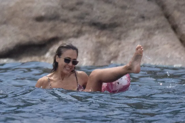 Jessica Alba floating in water with a bare foot raised.
