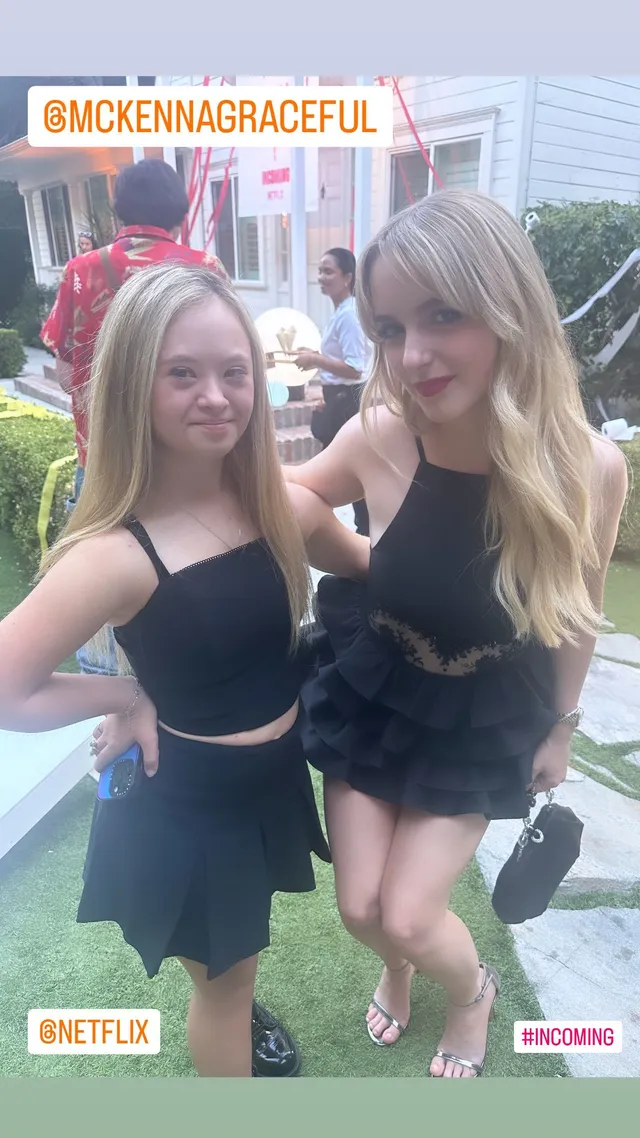 Mckenna Grace posing beside a friend outdoors in a black outfit and heels.