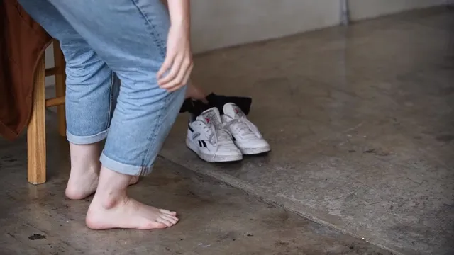 Victoria Pedretti a close-up of bare feet beside a pair of sneakers.