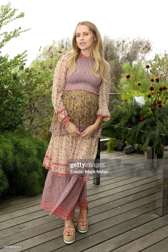 Teresa Palmer standing outdoors in a patterned layered outfit.