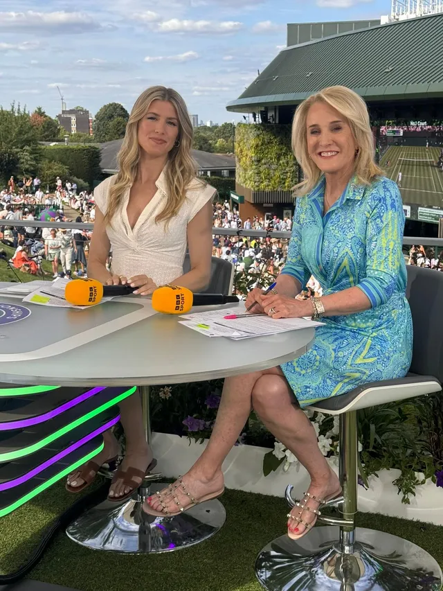 Eugenie Bouchard sitting in heeled sandals beside a television presenter at a tennis venue.