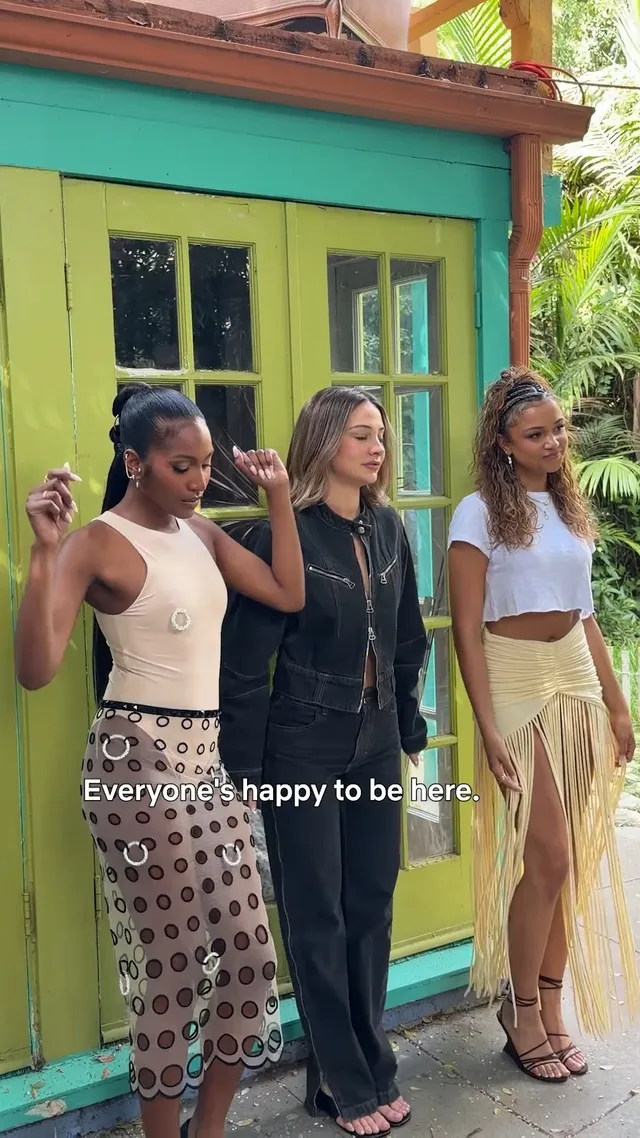 Madison Bailey posing with friends outdoors in a fringe skirt and heels.