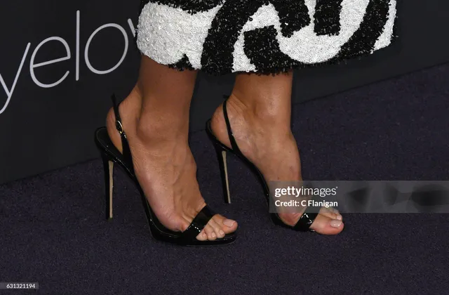 Heidi Klum wearing black ankle-strap heels.