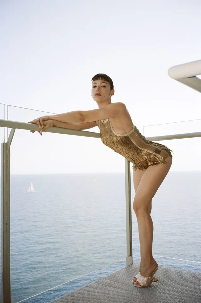 Úrsula Corberó posing outdoors in a patterned outfit and platform heels.