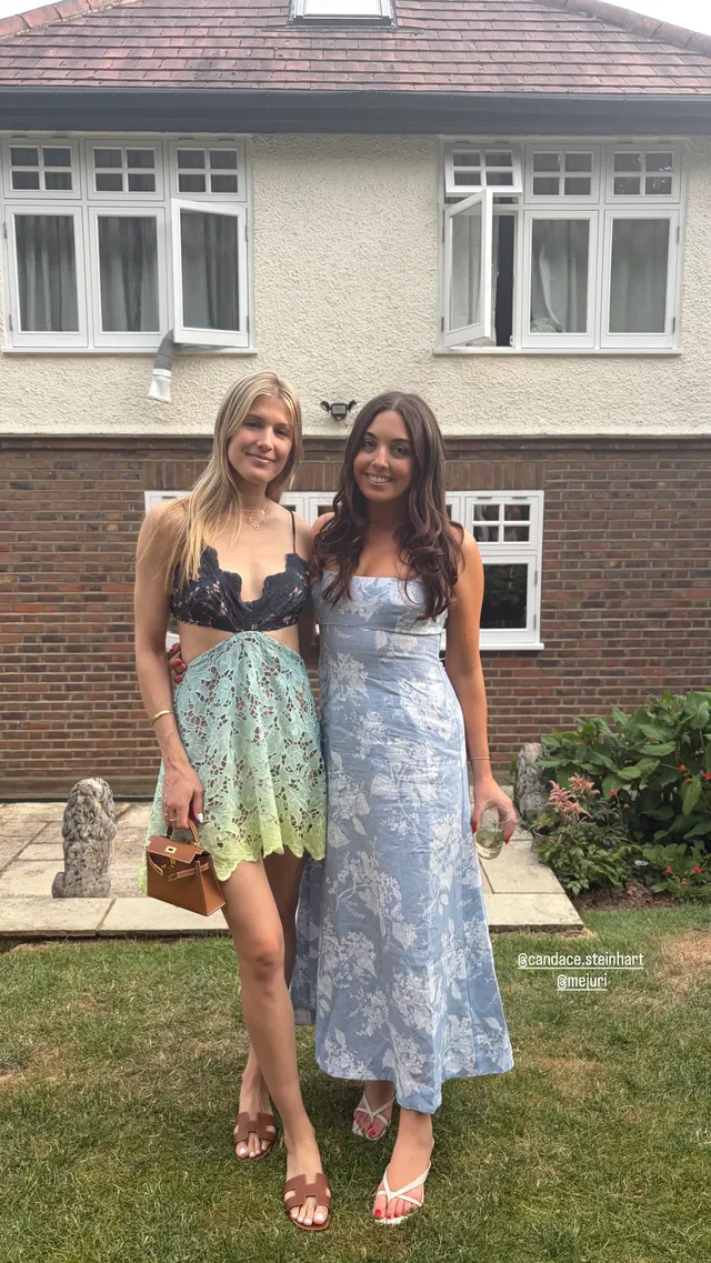 Eugenie Bouchard posing beside a companion in heeled sandals and a pale dress outdoors.