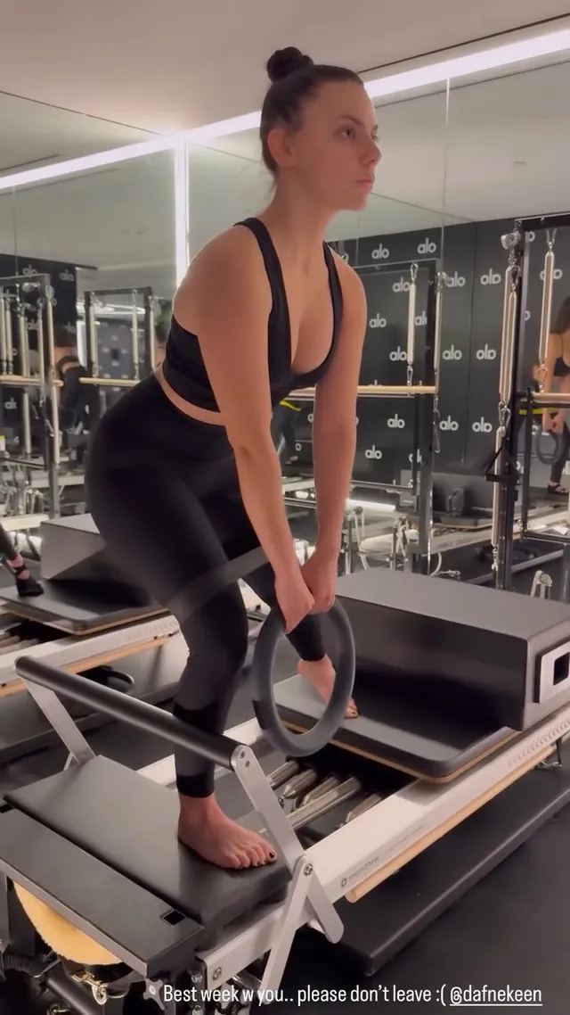 Dafne Keen standing barefoot on a Pilates reformer.