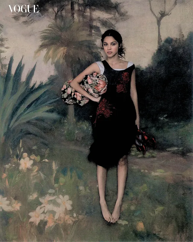 Olivia Rodrigo standing before a painted backdrop in a floral dress.