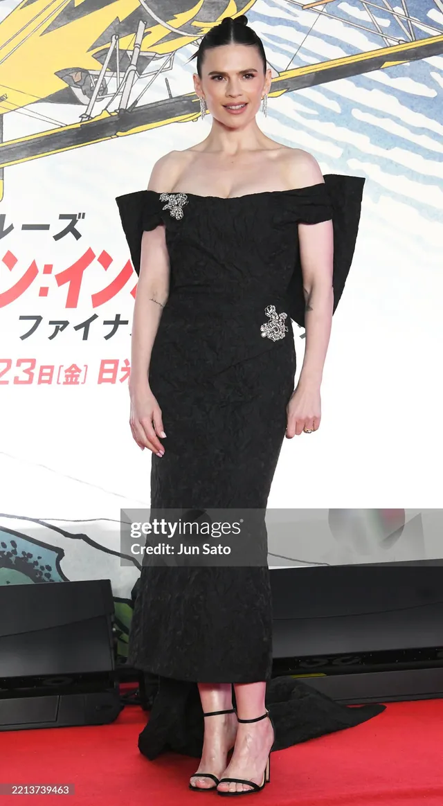 Hayley Atwell posing in an off shoulder black gown.
