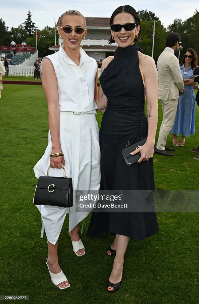 Hayley Atwell posing with a guest in a black dress.