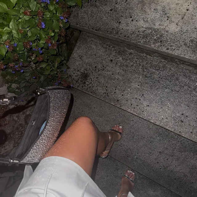 Alisha Lehmann wearing heeled sandals beside outdoor stone steps.