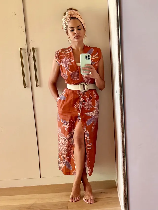 Eva Mendes taking a mirror photograph in an orange outfit.