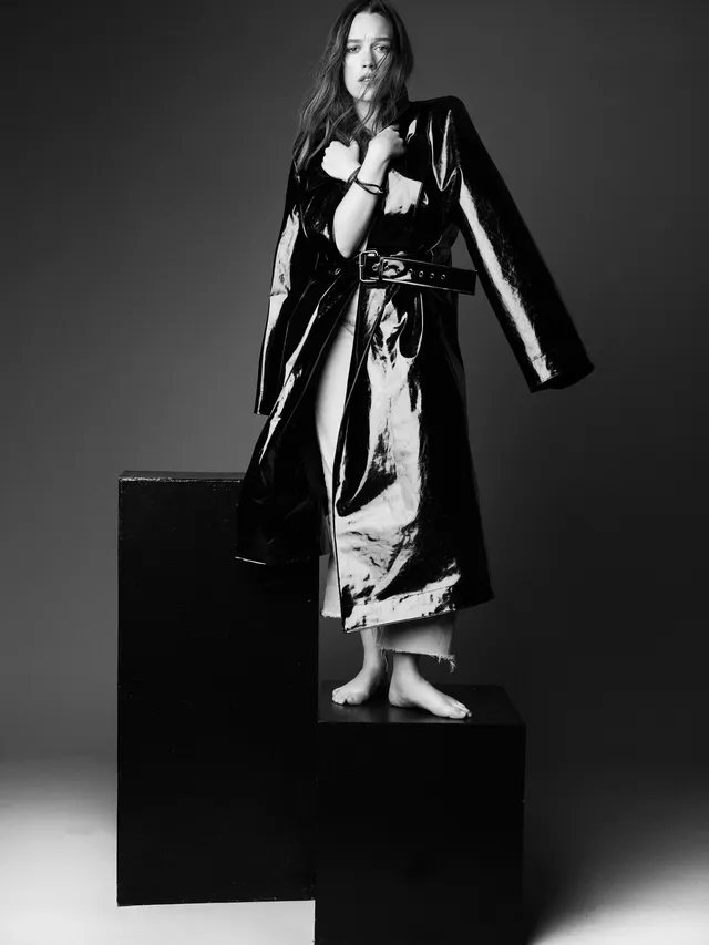 Victoria Pedretti posing on a platform for a black-and-white fashion portrait.