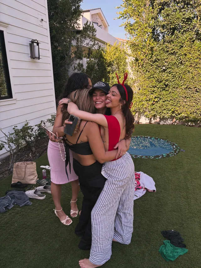 Sarah Hyland embracing companions during an outdoor gathering.