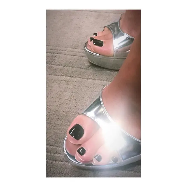 Naomi Scott wearing metallic platform heels in a close detail.