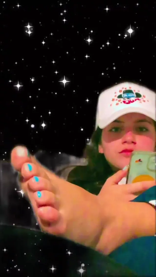 Isabela Merced raising a bare foot while taking a selfie.