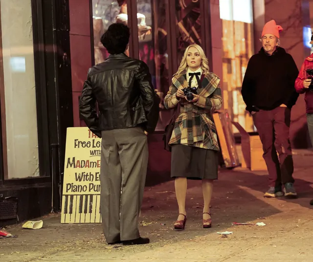 AnnaSophia Robb standing with cast members during a nighttime screen production.