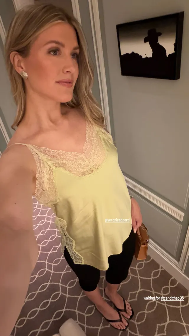 Eugenie Bouchard showing black flat sandals in an overhead mirror photograph.