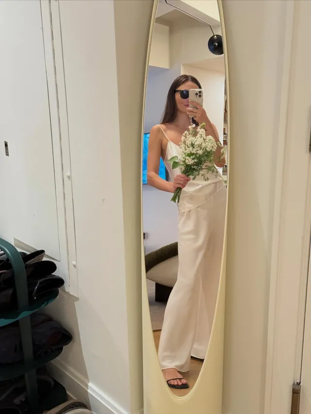 Phoebe Tonkin taking a mirror portrait in a pale dress and flat sandals.