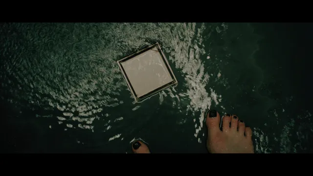 Keira Knightley a screen detail of a bare foot beside a floor drain.