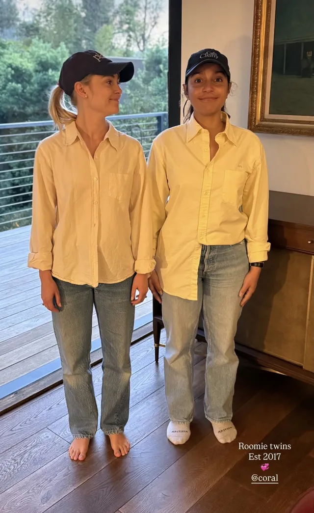 AnnaSophia Robb posing beside a companion in a pale shirt and jeans.