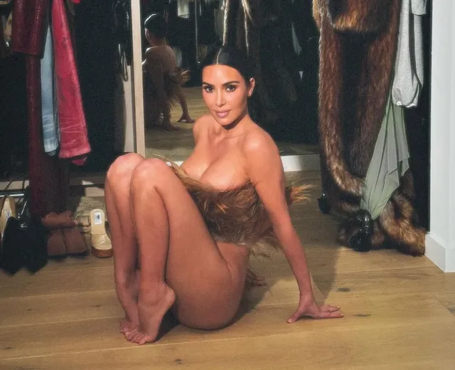 Kim Kardashian: seated barefoot on the floor of a dressing room.