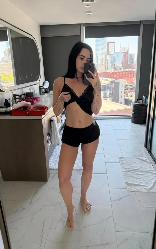 Demi Lovato posing barefoot for a mirror photograph.