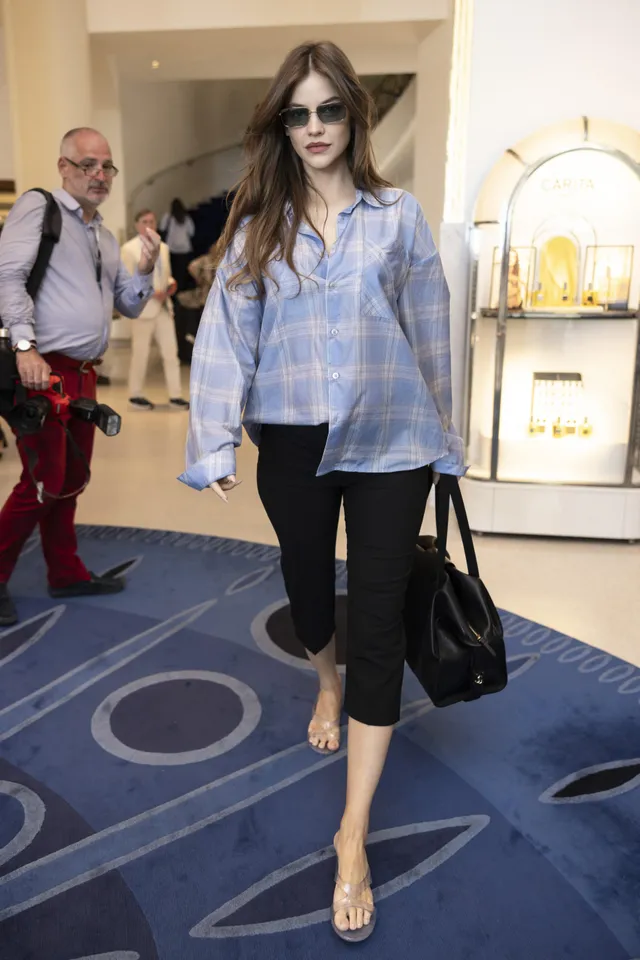 Barbara Palvin walking in clear heels with a blue shirt.
