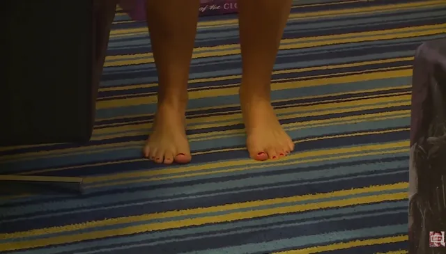 Tove Lo standing barefoot on a striped carpet.